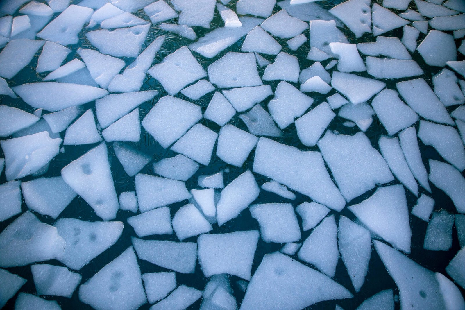 A detailed top-down view of broken ice on winter water, illustrating environmental themes.